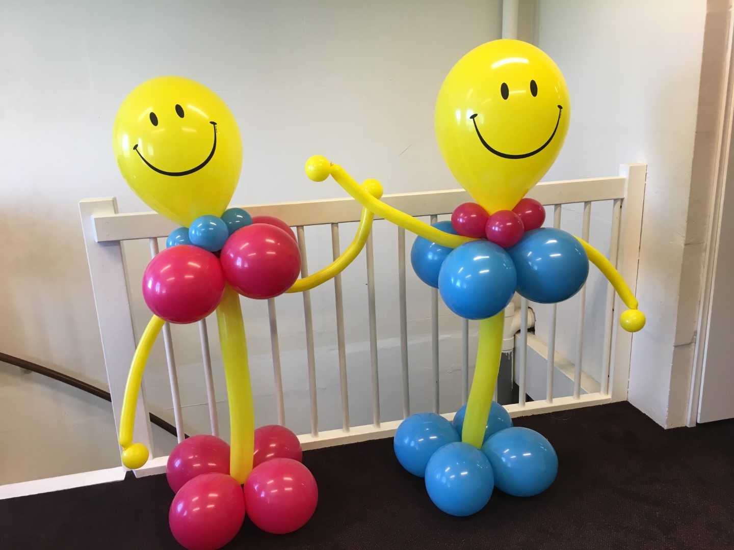 Smiley Ballonnenpilaren, samengesteld met een grote smiley ballon in de top en een lichaam van ballonnen. Alleen geschikt om binnen te plaatsen.