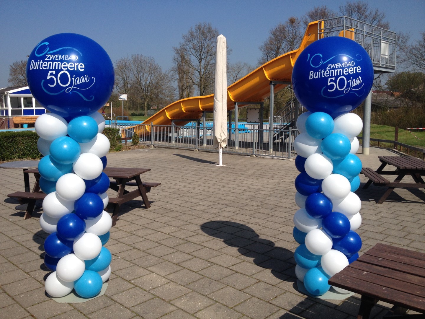 Ballonnenpilaren met een grote beschreven topballon met een tekst naar keuze. Stijl en samenstelling in overleg aan te passen naar uw wensen.