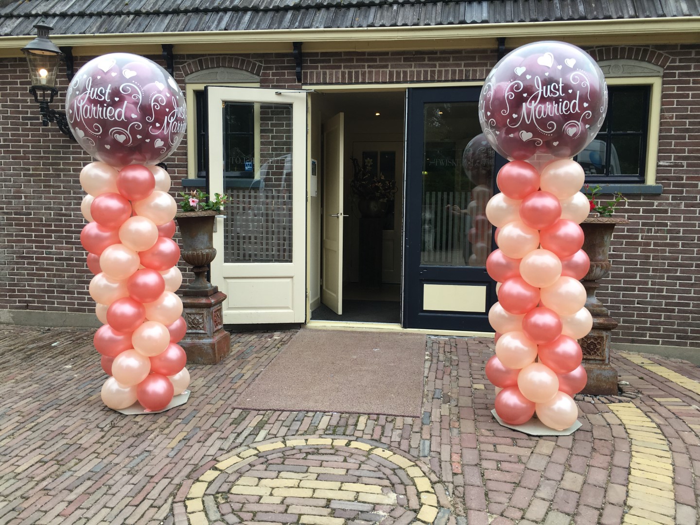Ballonnenpilaren met gestufde topballon. Ballonnenpilaren met transparante bedrukte topballon, gevulde met massief gekleurde standaard ballonnen.